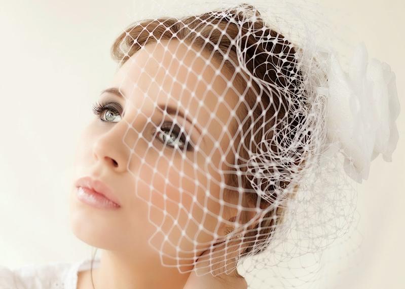 Model wearing birdcage wedding veil and smokey eyes nude lips bridal makeup